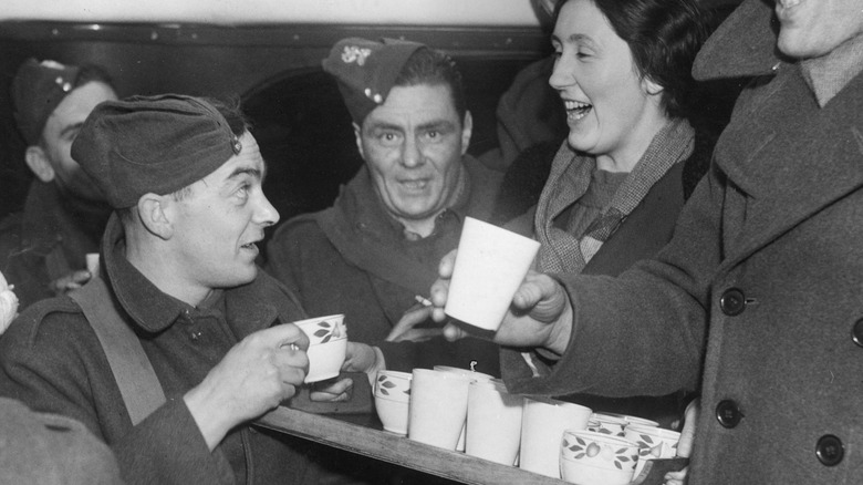 World War II soldiers are served coffee on a tray