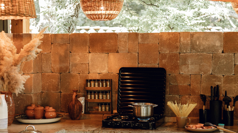 A natrual, earthy outdoor kitchen with a small propane stove