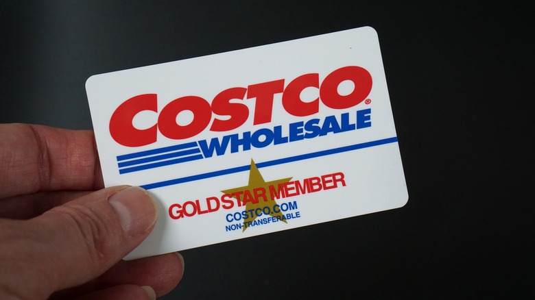 a hand holding a Costco membership card