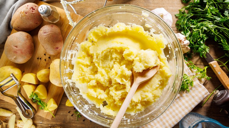 Wooden spoon in glass bowl of mashed potatoes