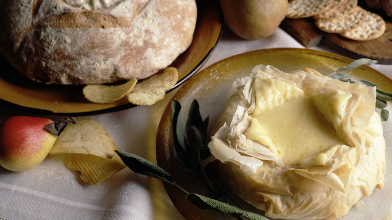 Baked brie on yellow plate next to sourdough bread