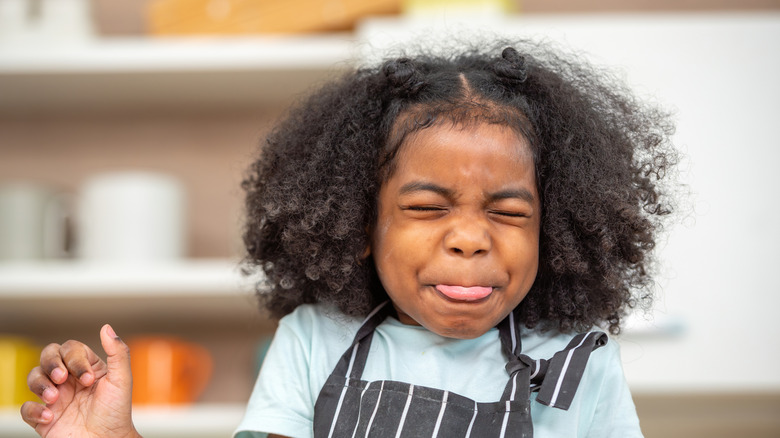 A child making a face after tasting something bad