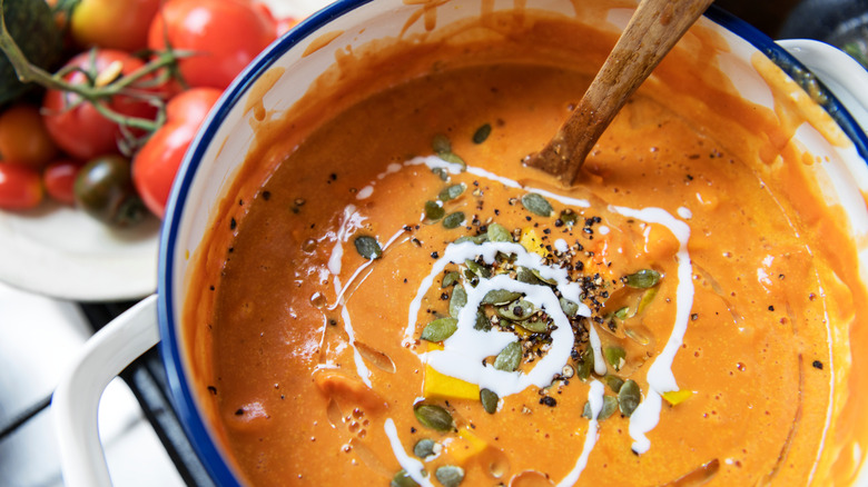 creamy tomato soup in a stock pot with seeds and cream