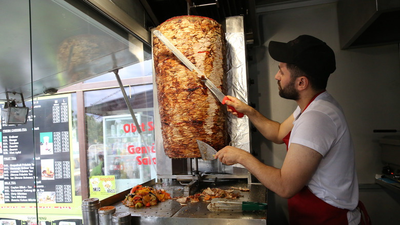 A worker slicing doner kebab meat in a restaurant in Berlin.