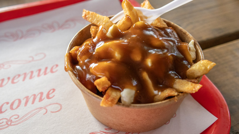 poutine in a take out container on a fast food tray