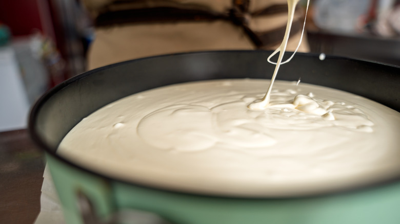 pouring cake batter into a pan