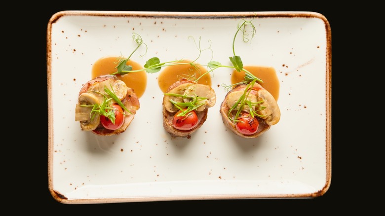 Rolls with roasted vegetables and pea tendril drizzled with sauce