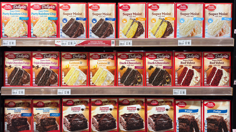 Grocery store shelves full of a variety of boxed cake mixes.