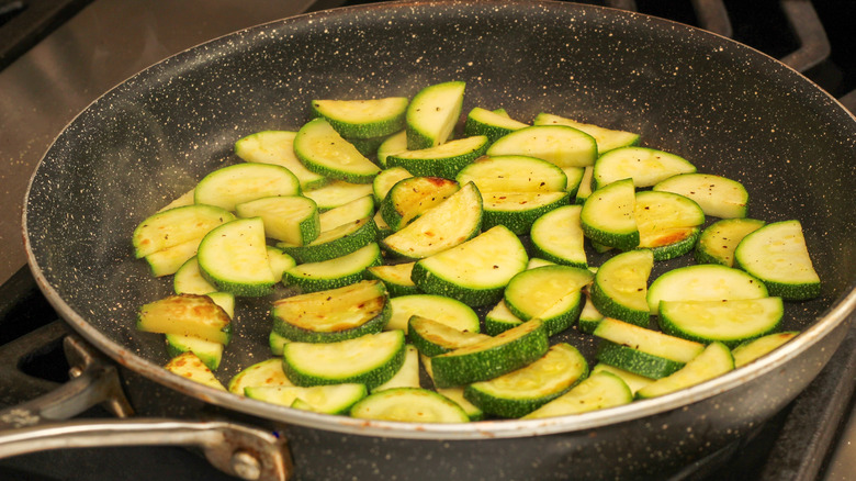 zucchini sauteeing in a pan