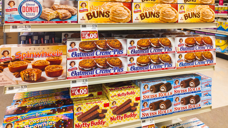 Several boxes of Little Debbie treats appear on a grocery store's shelves.