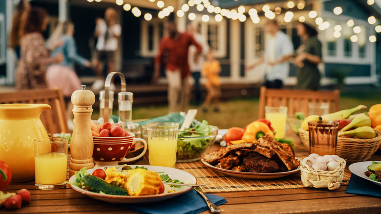 A variety of dishes on a wooden table outdoors