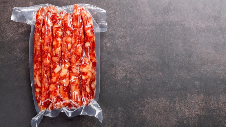 Sausages in a vacuum bag on a gray background
