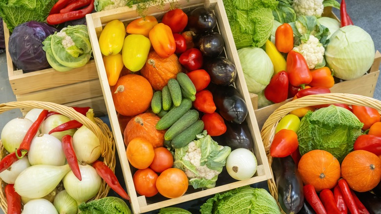A spread of fresh, colorful vegetables in wooden boxes and baskets