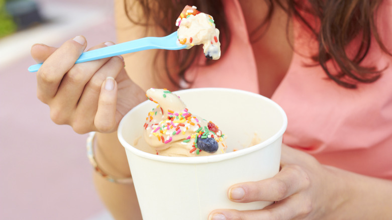 A young woman enjoying a cup of frozen yogurt