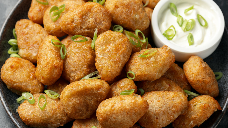 Jalapeño bites with dipping sauce and green onion garnish