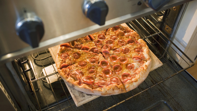 Pepperoni pizza going into oven