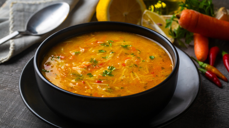 chicken and vegetable soup in a black bowl