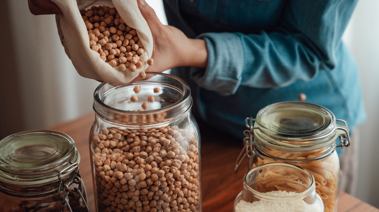 bulk foods being poured into airtight glass canisters