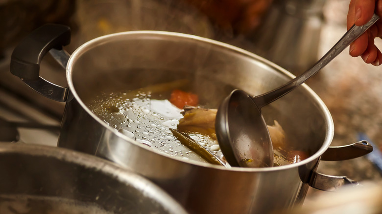 Ladle skimming off soup pot