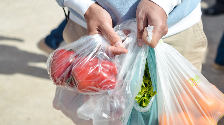 person struggling with multiple grocery bags