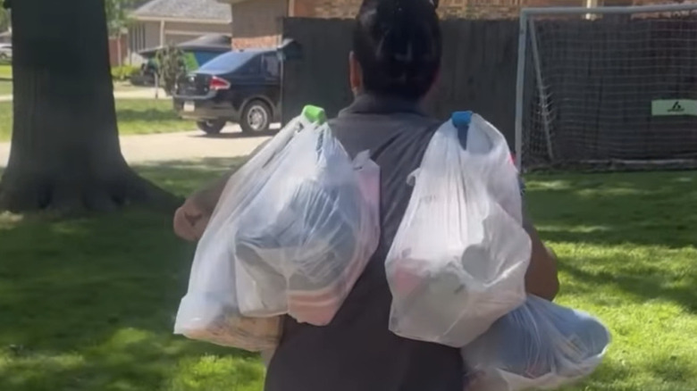 guy carrying multiple grocery bags on his shoulders