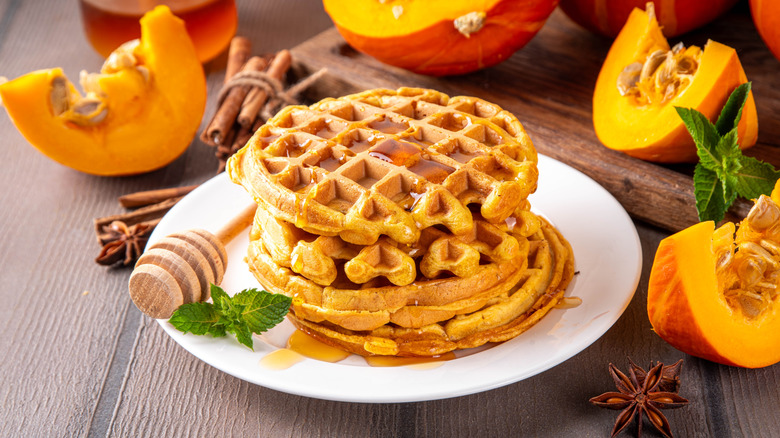 A plate of waffles covered in honey.