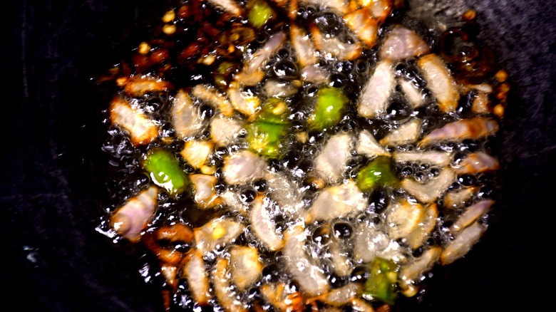 garlic, onion, and chili slices frying in oil