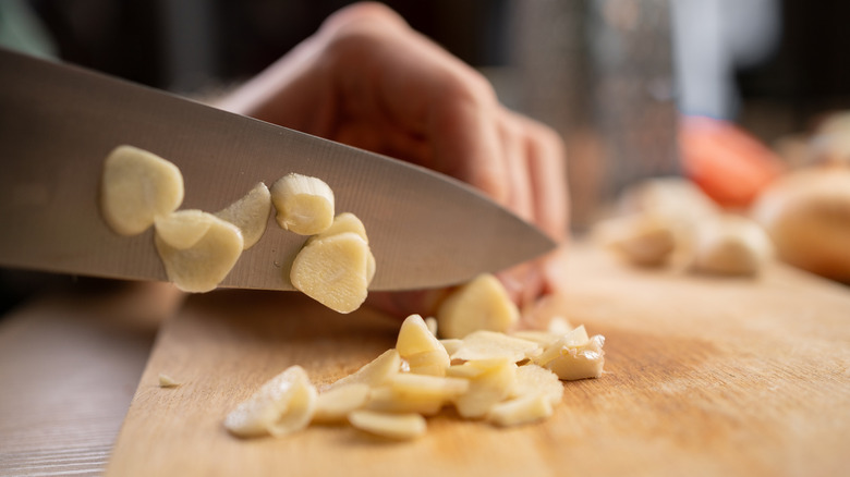 Close-up shot of someone chopping fresh garlic