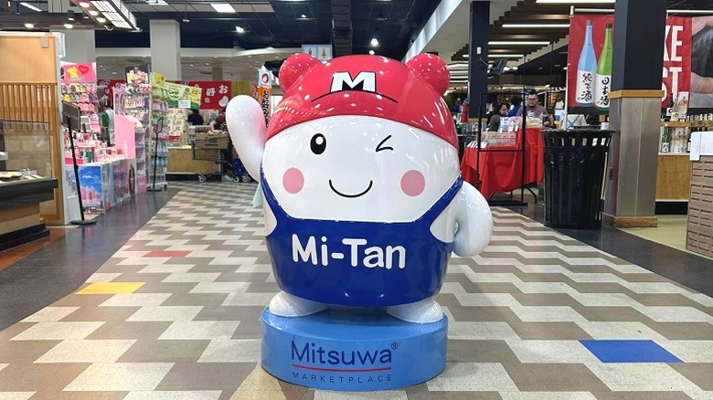 Statue of Mitsuwa Marketplace mascot Mi-Tan standing inside store aisle
