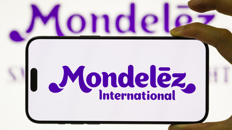 Mondelēz International logo on a smart phone and blurred in the background