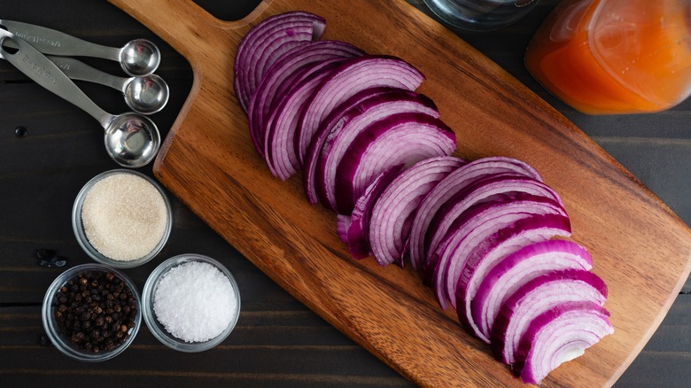 Sliced red onion on a wooden cutting board.
