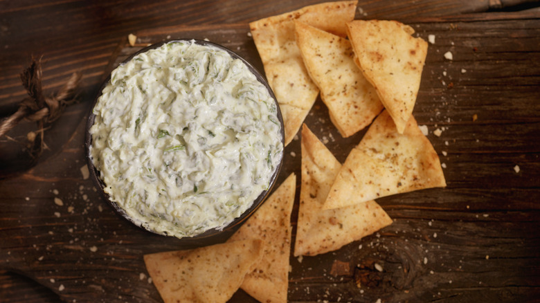 Bowl of dip with tortilla chips on a wooden table