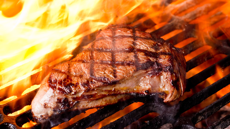 Flame engulfing a steak slab.
