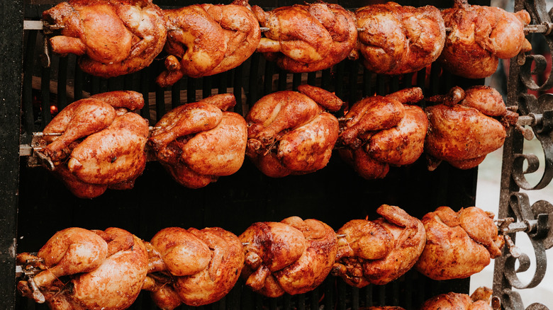 Rows of rotisserie chicken being cooked