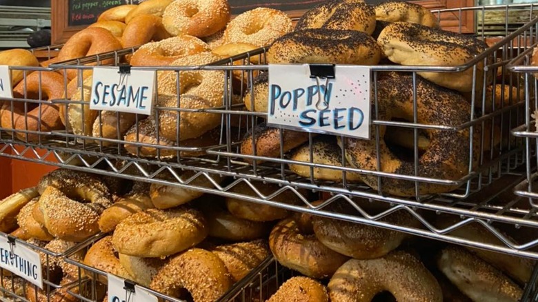 Baskets of various bagels on wire shelves