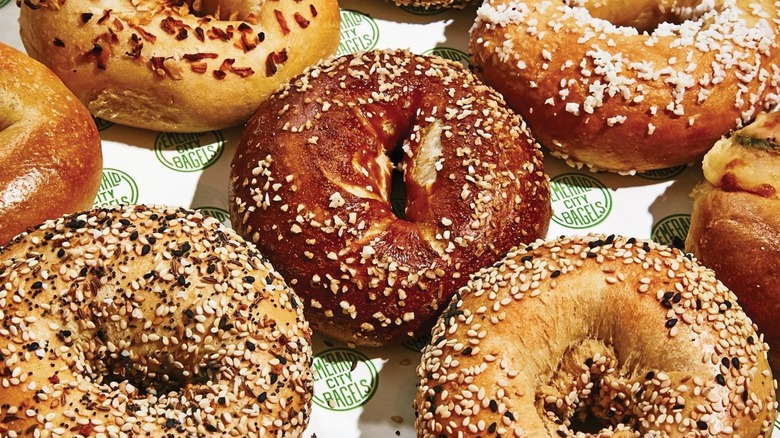 Assorted bagels on white and green branded paper