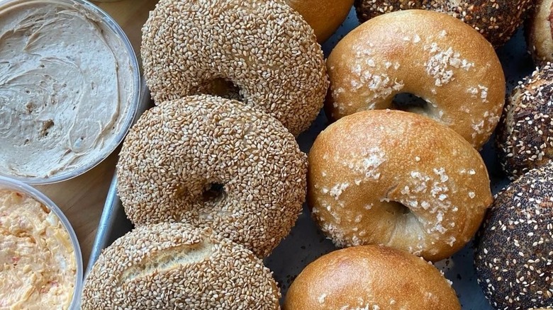 Assortment of bagels on tray alongside containers of cream cheeses