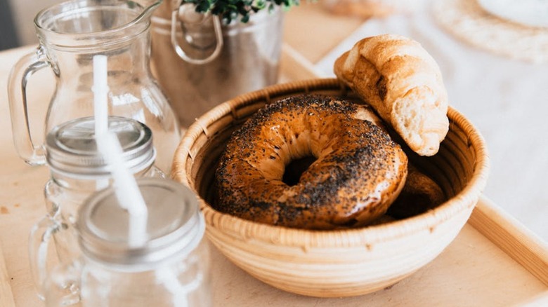 Bagels in wicker basket with jars on tray