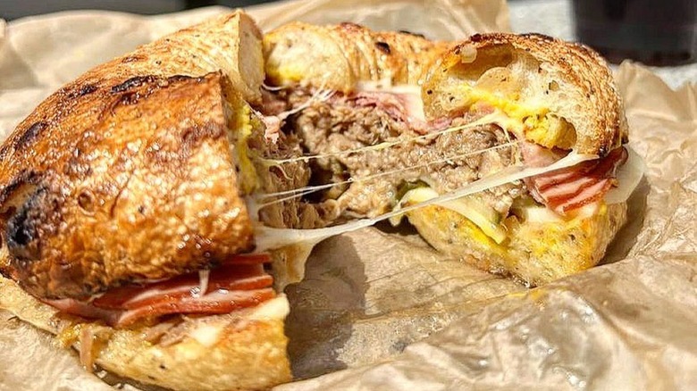 Bagel cut in half to show cheese, ham, and sausage