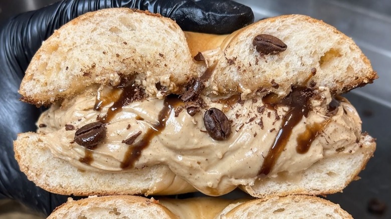 Half of bagel sandwich with espresso martini cream cheese, coffee beans, and chocolate