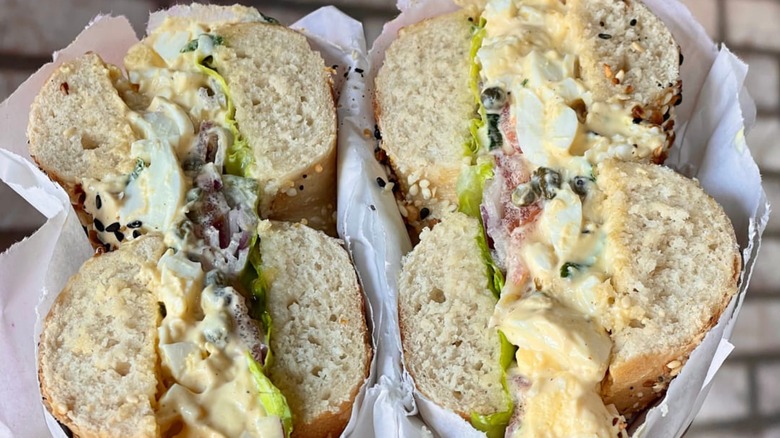 Two halves of an egg salad bagel