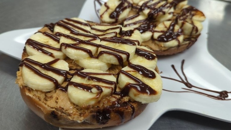 Peanut butter and banana on bagel halves with chocolate syrup
