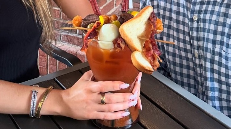 A woman's hand holding a giant Bloody Mary at The Nook Piedmont Park