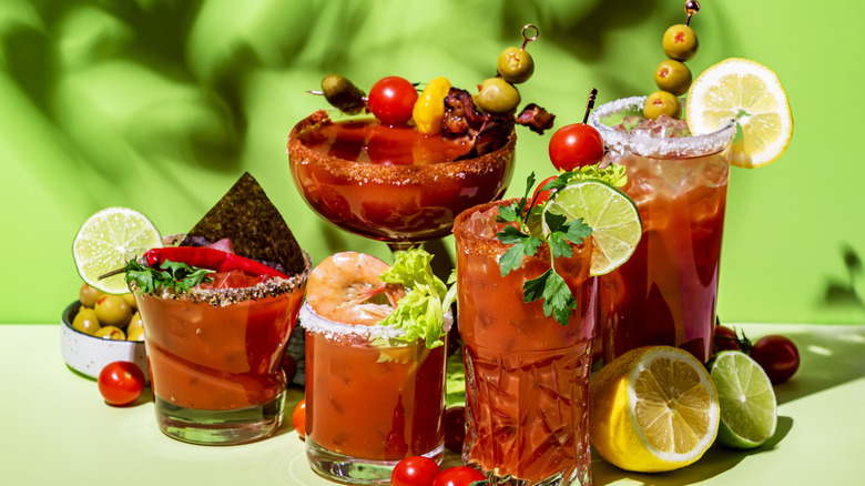 An assortment of Bloody Marys with green background
