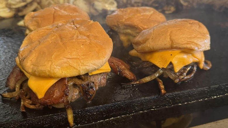 Bacon cheeseburgers on the griddle at Nic's Grill.
