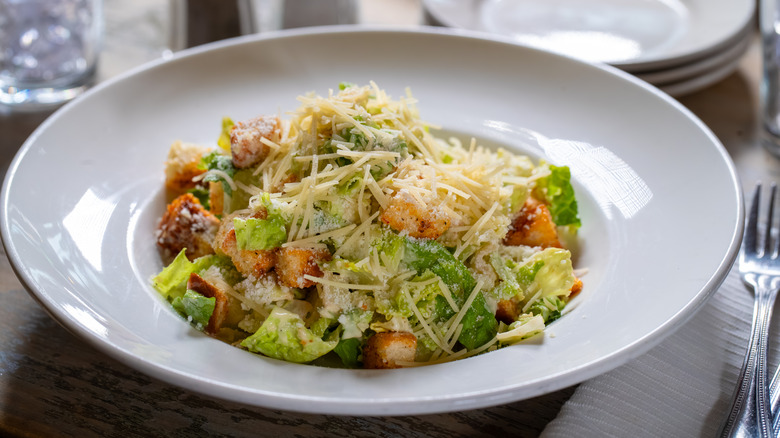 A plate of Caesar salad on a table