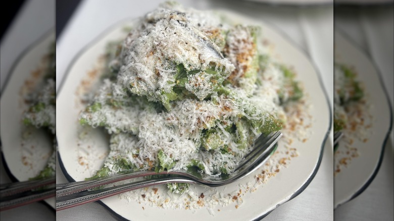A Caesar salad topped with a generous dusting of Parmesan cheese and breadcrumbs