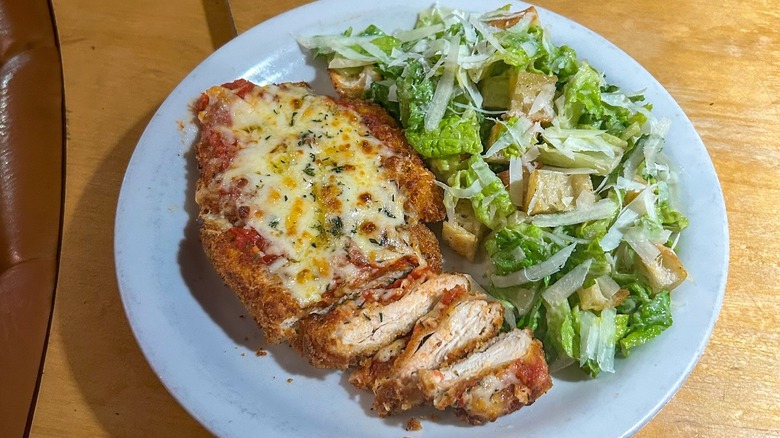 A plate of chicken parm from Trattoria Zaza with a Caesar salad on the side