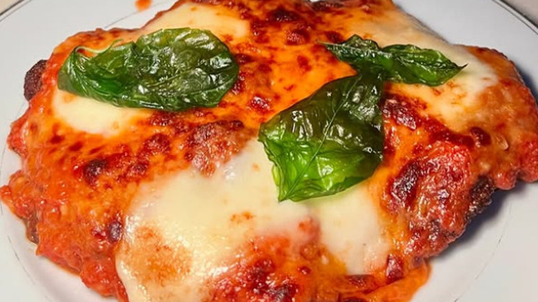 Chicken parm at Elina's in Chicago topped with fresh basil leaves