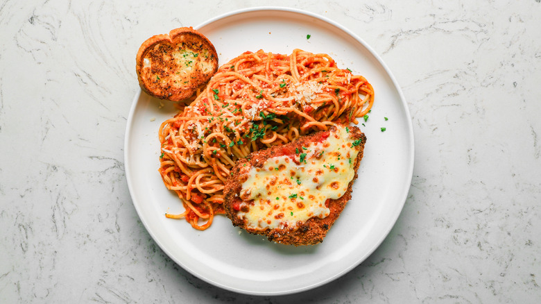 A plate of chicken parm on a marble countertop